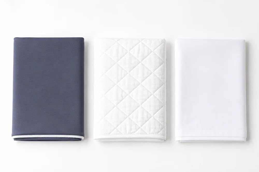 Trois textiles plies cote a cote : housse, protege-oreiller et taie
